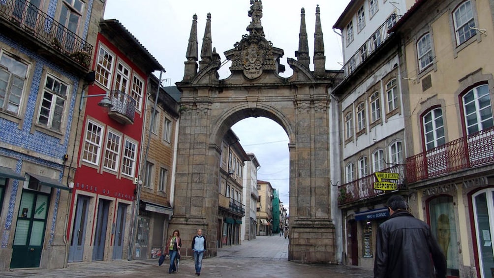 Large stone archway between buildings in Braga