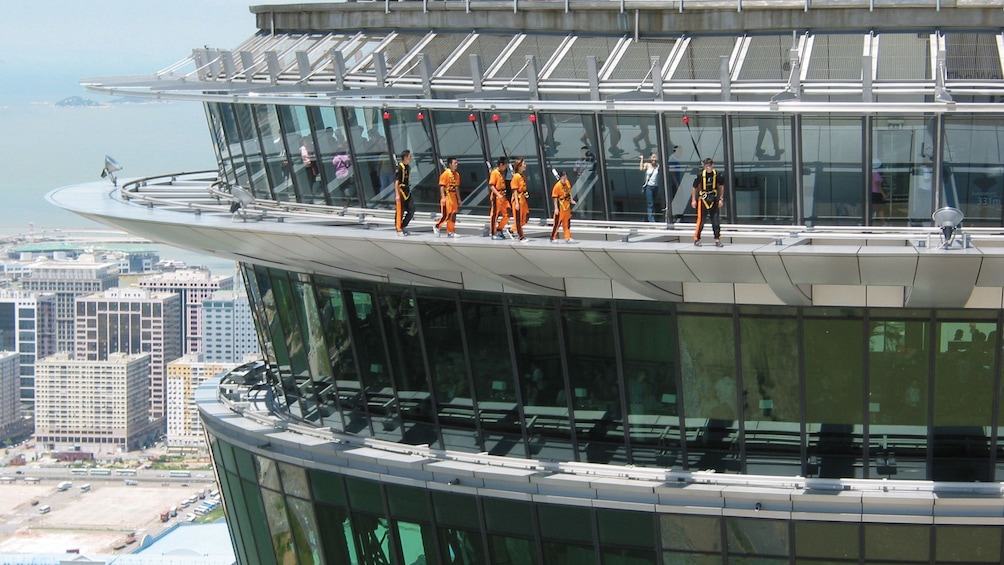 People walking along the outside of the Macau tower