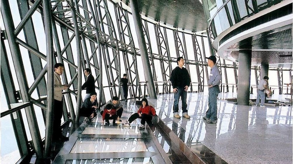 A group of people on the observation deck of the Macau tower