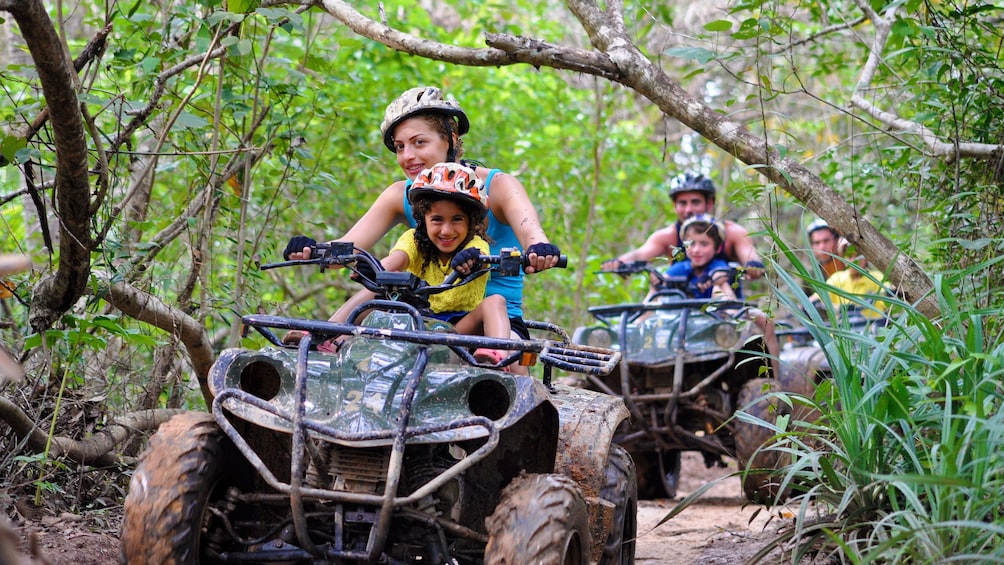 Mother and daughter riding through a muddy path in Phuket. 