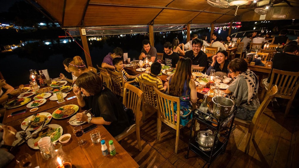 Guests enjoying their dinner aboard the Ping River Dinner Cruise in Chiang Mai 