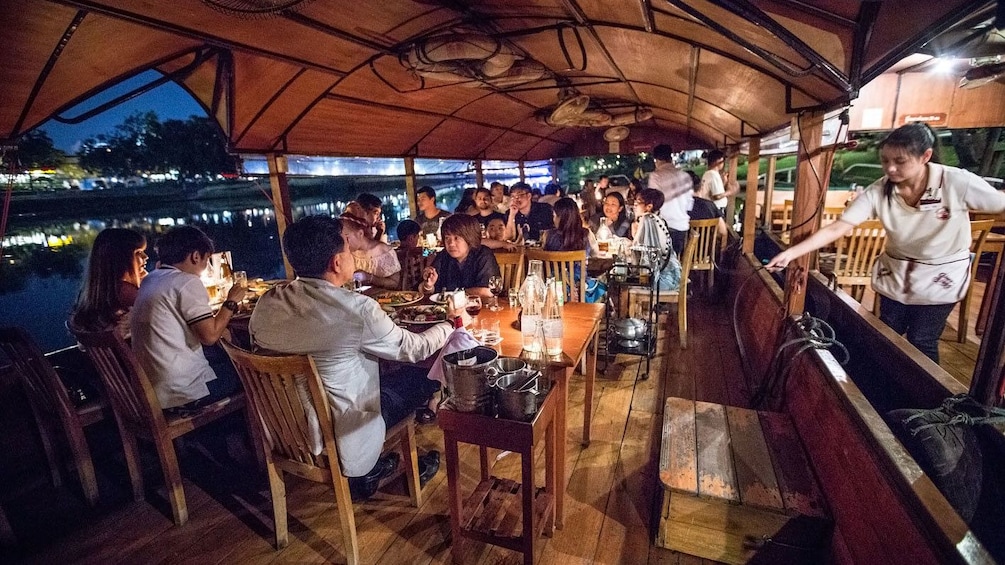 Guests enjoying their dinner aboard the Ping River Dinner Cruise in Chiang Mai