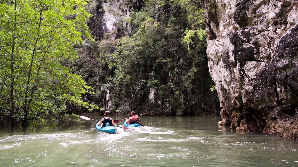 Kayakers paddling past rock formations in Ao Talen