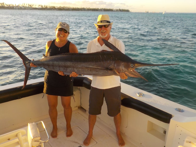 Couple hold large fish on a boat in Punta Cana