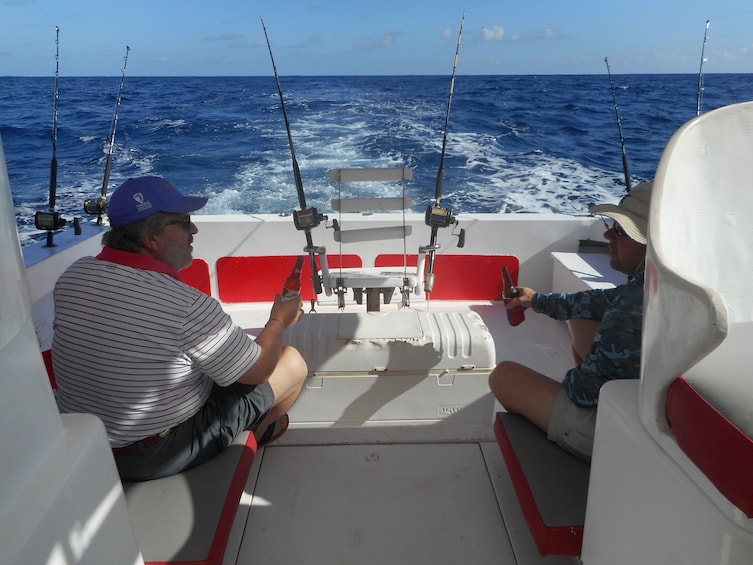 Two men enjoy beers on the deck of fishing boat in Punta Cana