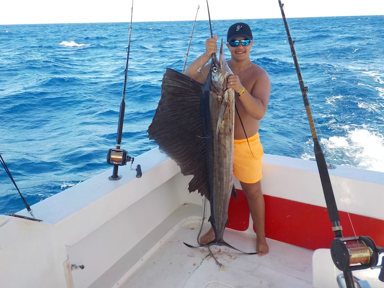 Man holds large swordfish on fishing boat in Punta Cana
