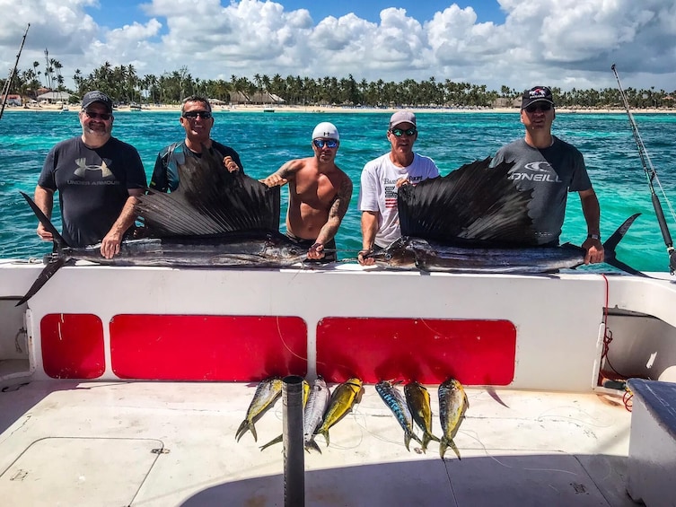 Group of friends hold fish on Punta Cana fishing boat