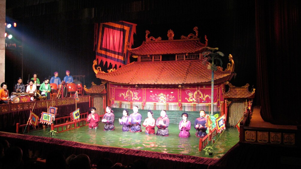performers half submerged in water on stage in Hanoi