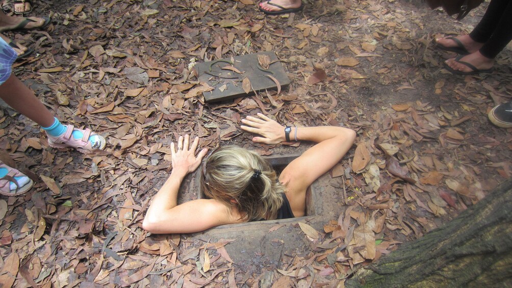 Woman climbing out of the Cu Chi Tunnels in Tay Ninh Vietnam 