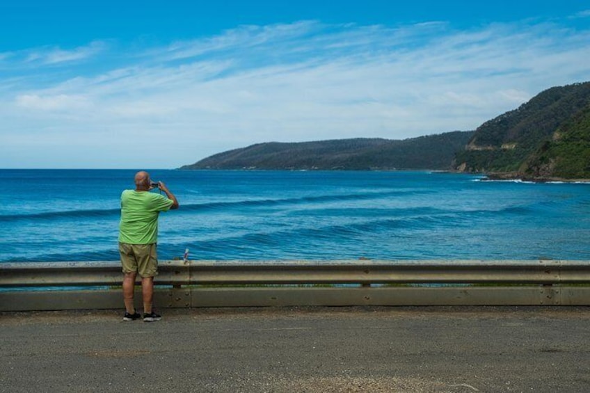 While traveling the Great Ocean Road in Australia, a visitor stops to snap a photo of the blindingly-blue coastline.