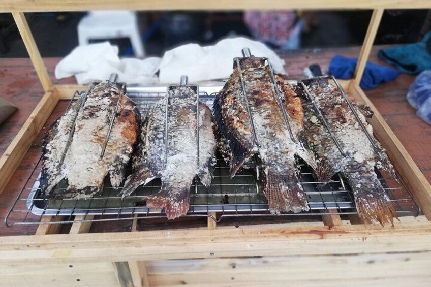 Salt Crusted Fish served with herbs & salad.