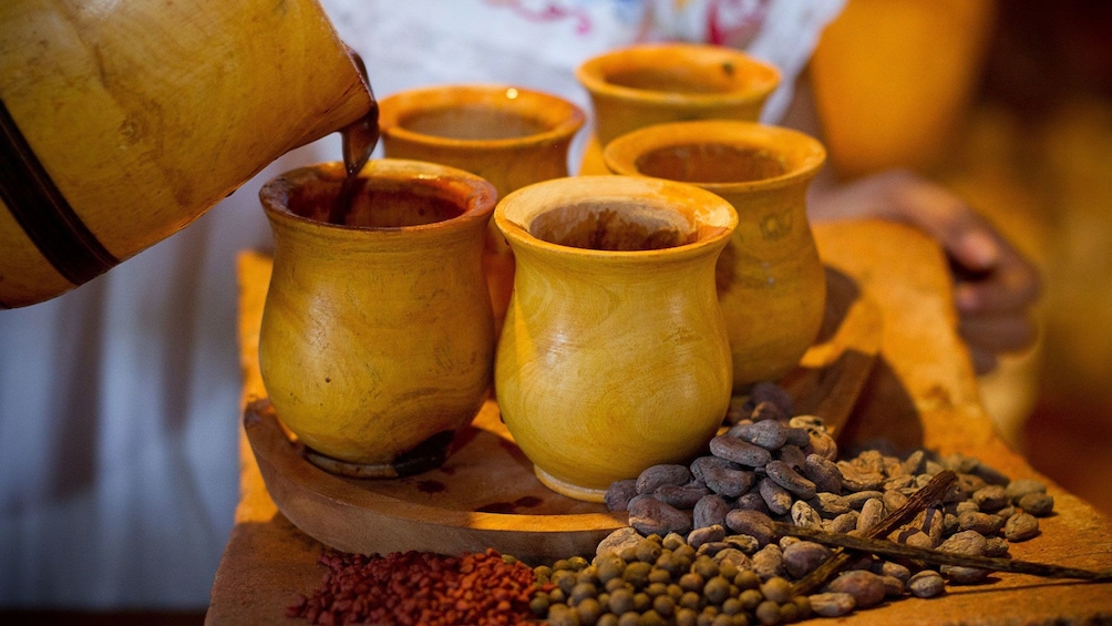 Show item 1 of 5. Pouring authentic hot chocolate into traditional wooden cups in Mexico