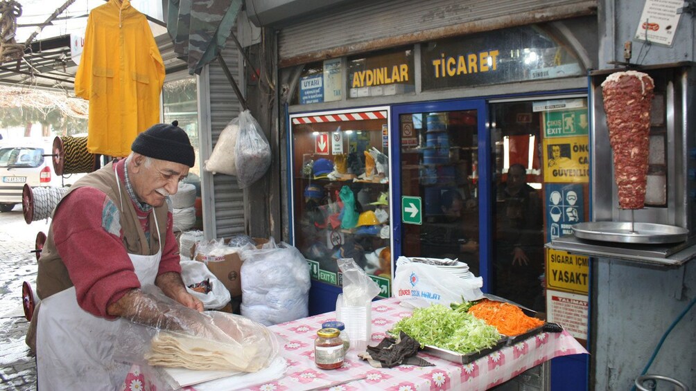 Foto 4 von 5 laden Man standing and preparing food at a food stall in Istanbul