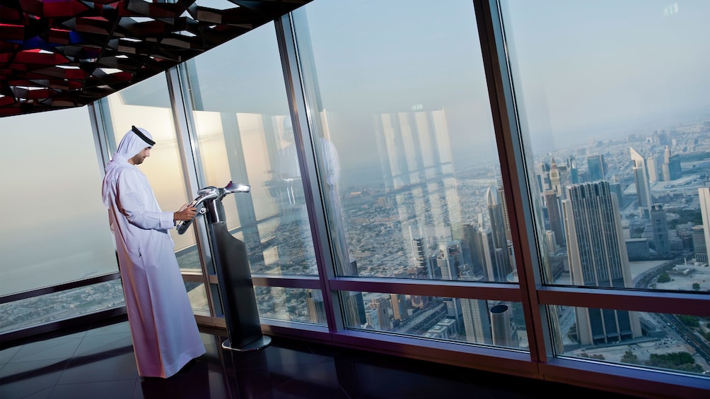 Man looking out at the city of Dubai from the observation deck at Burj Khalifa