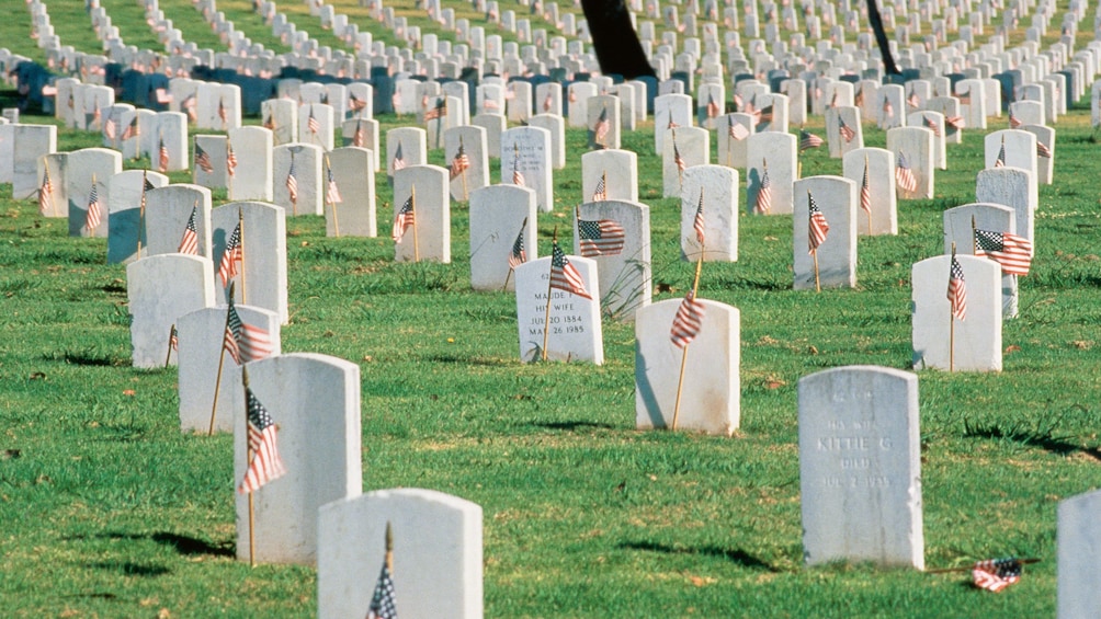 Small American flags mark the ground in front of the veterans headstones at Arlington National Cemetery in Washington DC