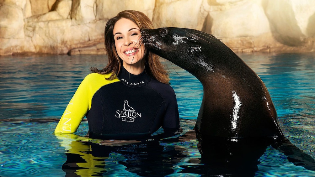 Woman being kissed by a Sea Lion at Aquaventure Waterpark in Dubai