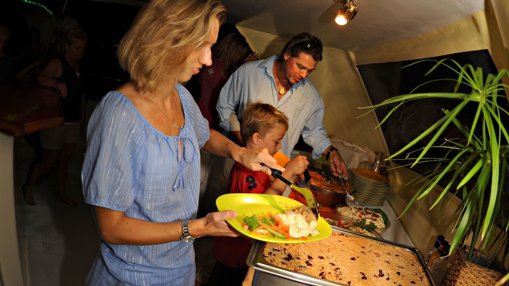 Family enjoying dinner served onboard the Tango catamaran