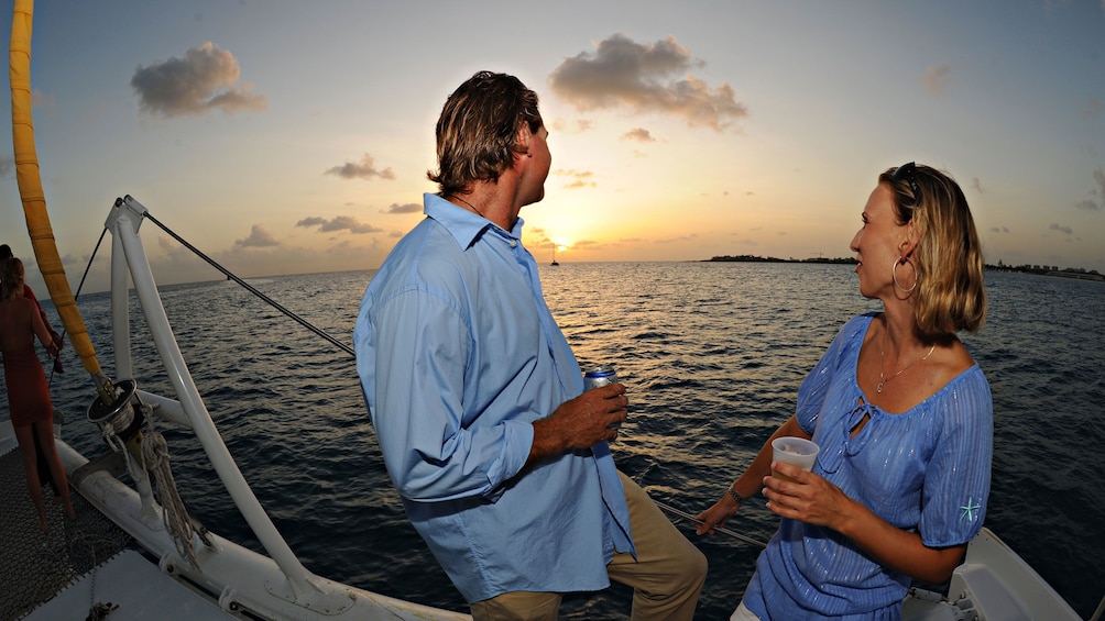 Couple enjoying the view of the sunset onboard the Tango Catamaran