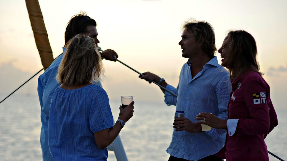 Couples enjoying drinks and views of the sunset from the Lambada catamaran