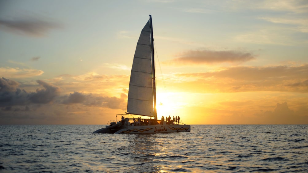 Lambada catamaran sailing through Simpson Bay during sunset