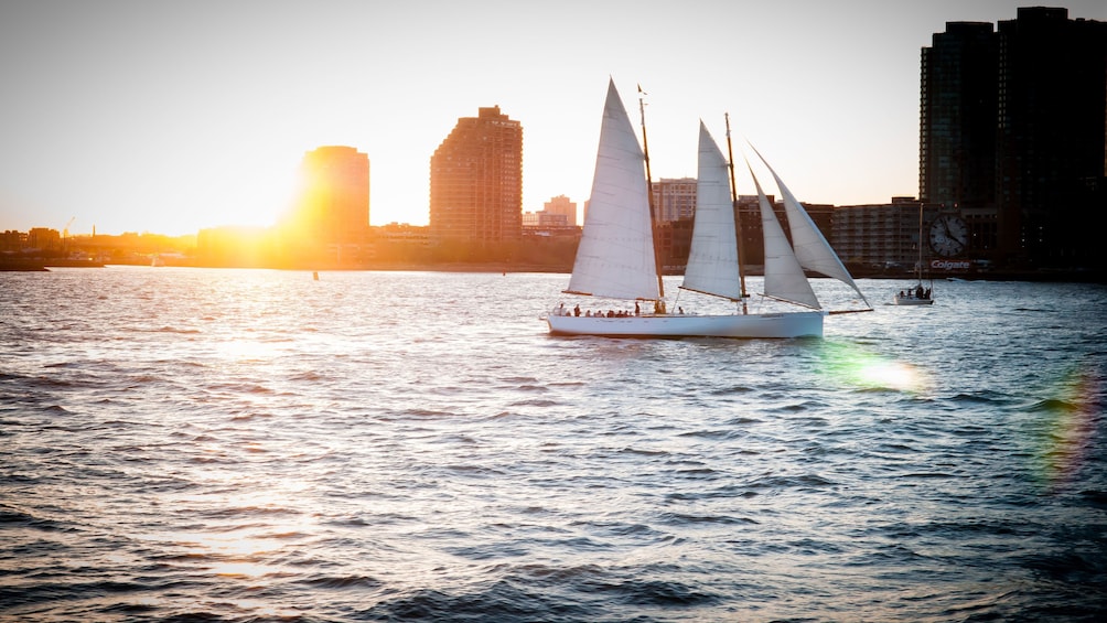 Sailboat with city in the distance at sunset in New York
