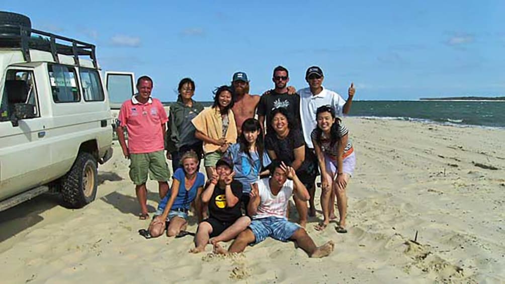 group of friends together on sandy beach of Brisbane