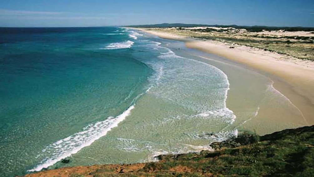 ocean surf breaking against beach in Brisbane