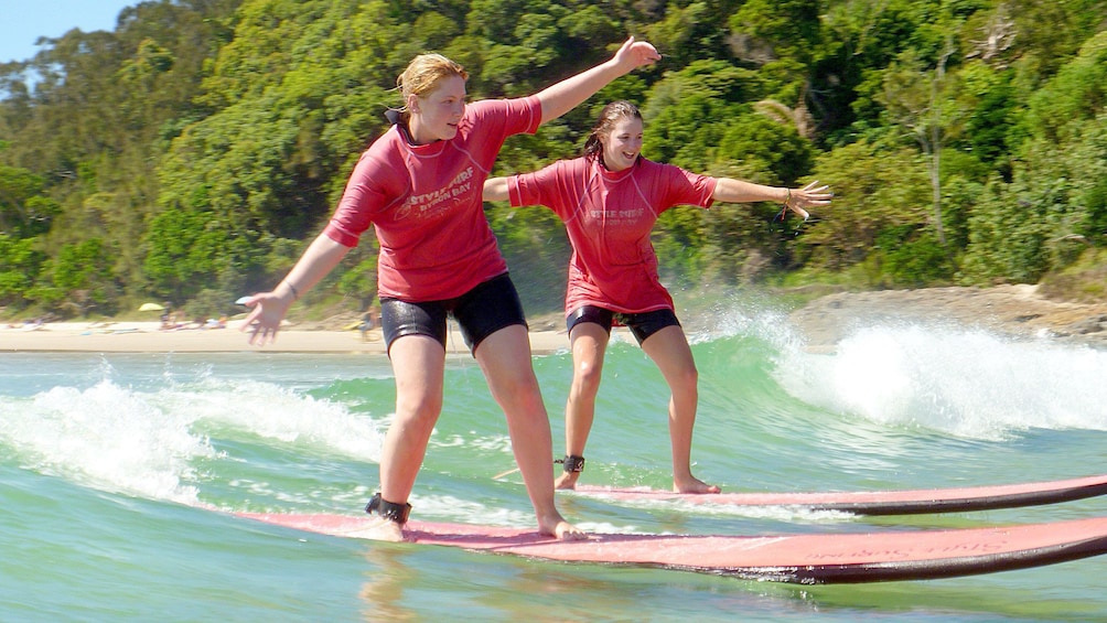 Balancing girls learning how to surf of Byron Bay.