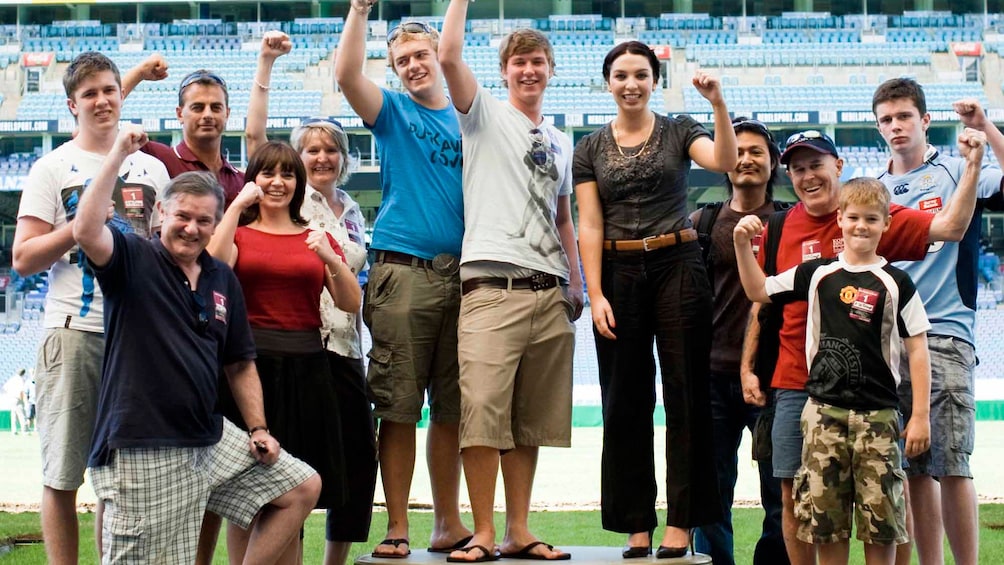 Show item 3 of 5. group of people cheer inside stadium in Canberra