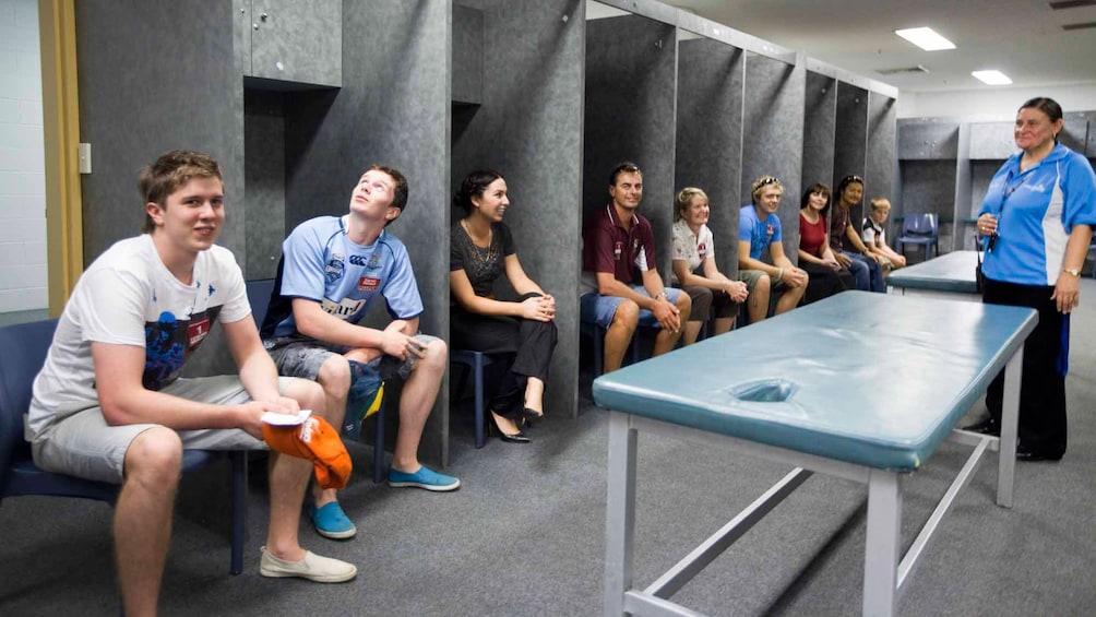 Show item 2 of 5. Many people sitting in locker room of stadium in Canberra