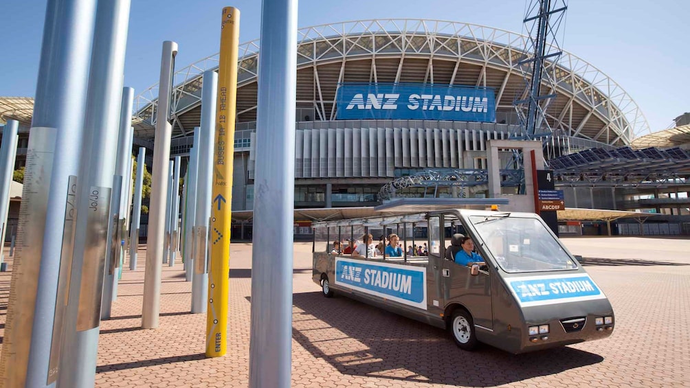Show item 1 of 5. group of tourist in shuttle van by stadium in Canberra