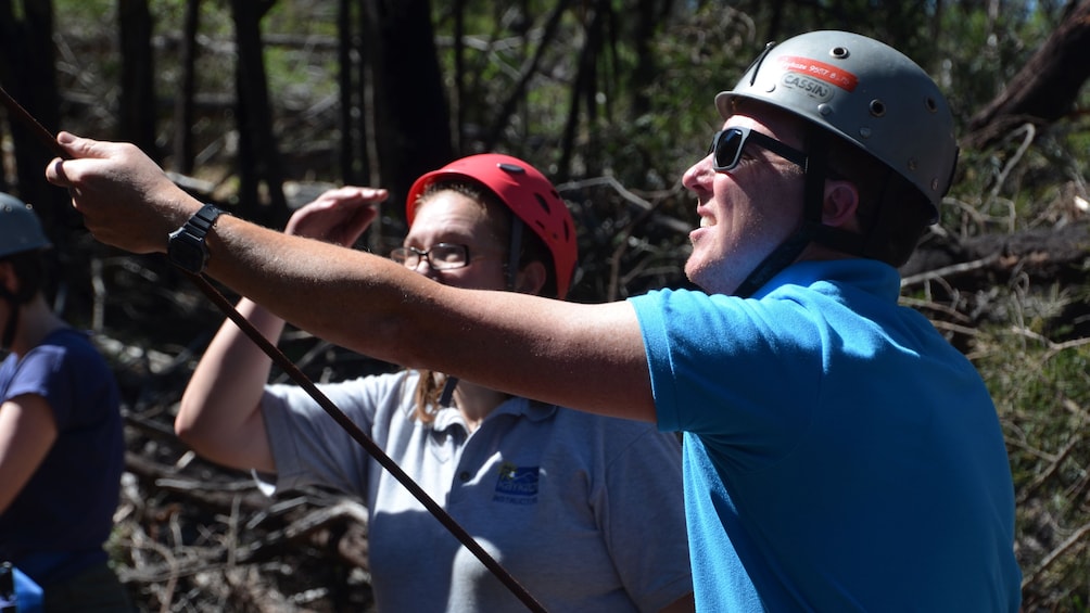 man in safety gear tests line of rock climbers in Melbourne