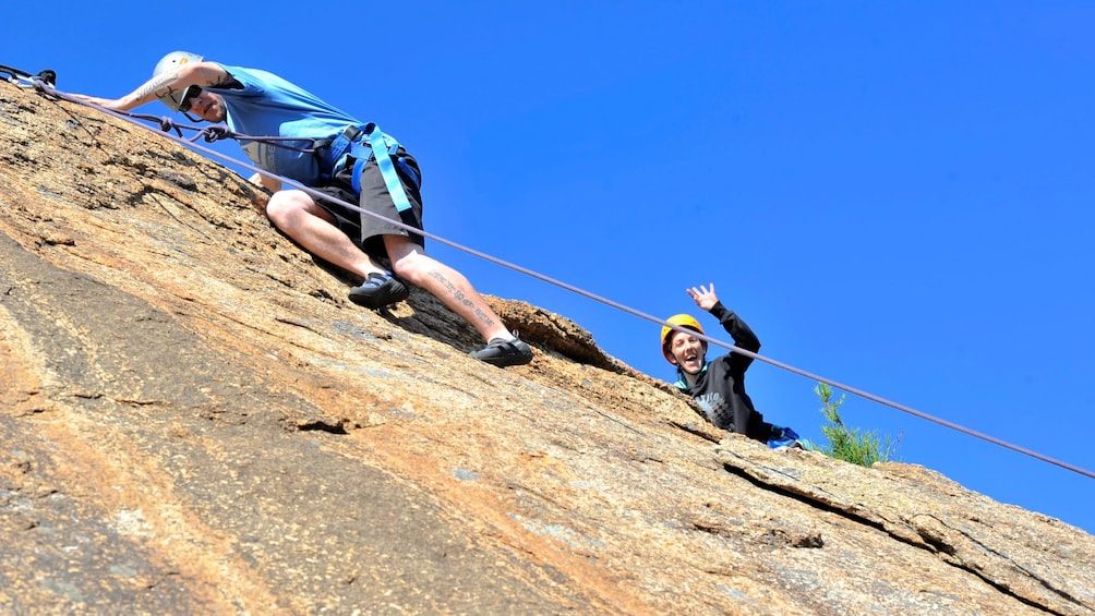 man carefully scaling rock wall in Melbourne