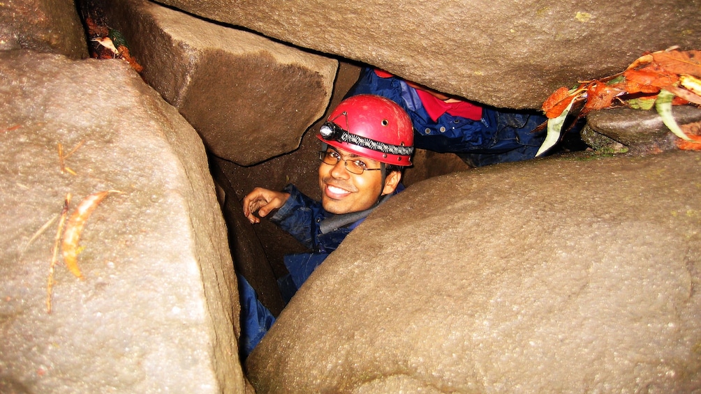 happy man in tight space between boulders in Melbourne