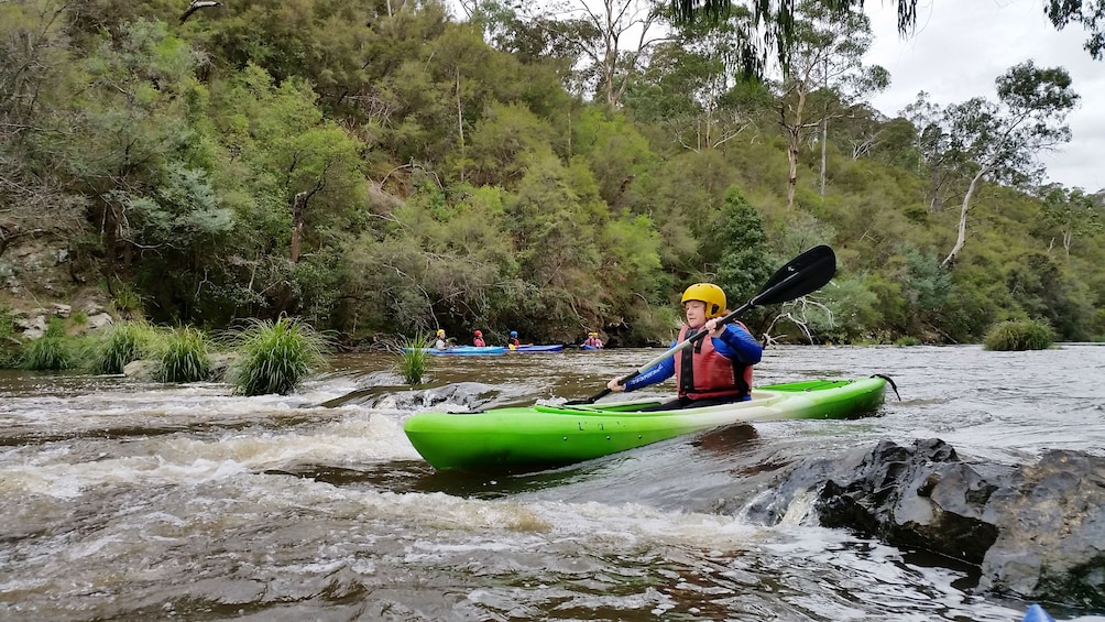 man in kayak paddles through river rapids in Melbourne