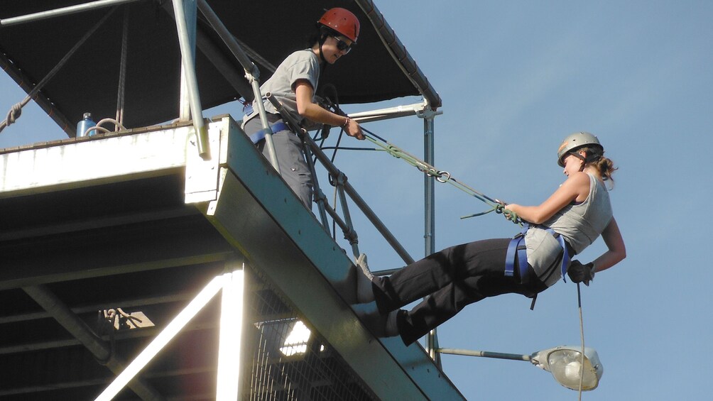 woman in saefty gear begin repelling down tower in Melbourne