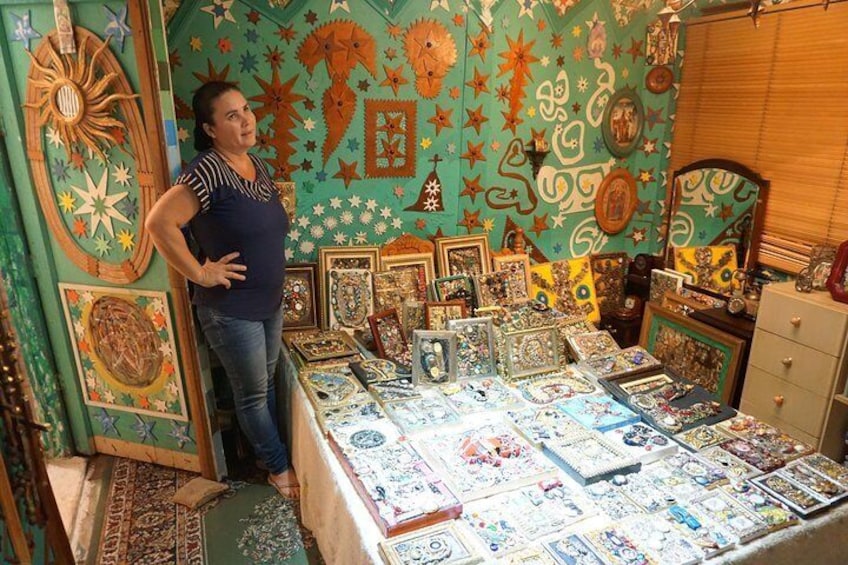 Estevao's wife showing his artwork on their own bed
