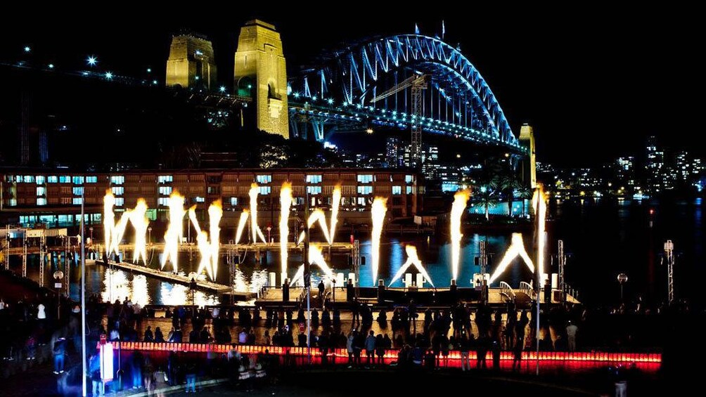 light designs in front of lighted Sydney harbor bridge at night