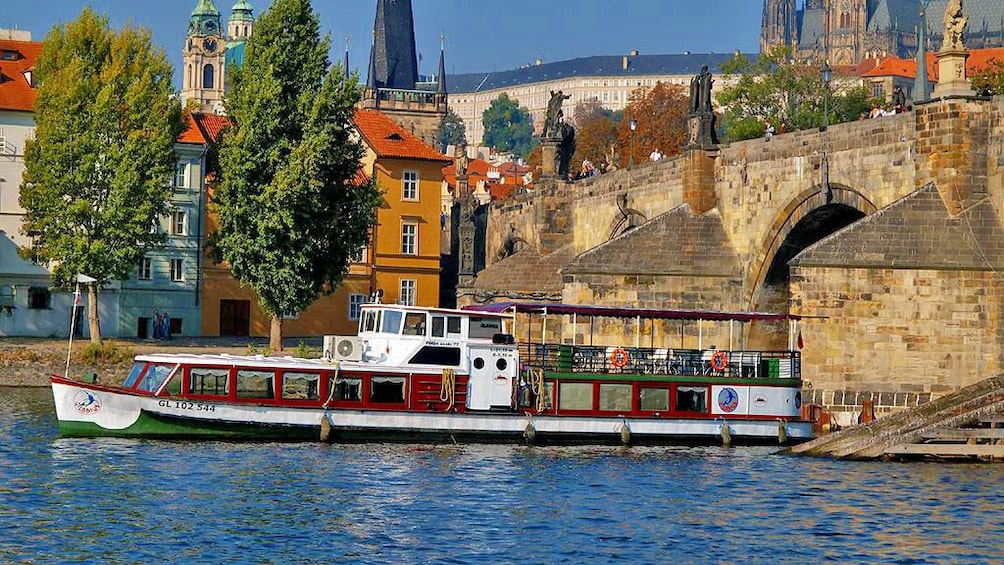 Foto 1 von 10 laden Boat passing under a bridge in the Vltava River in Prague