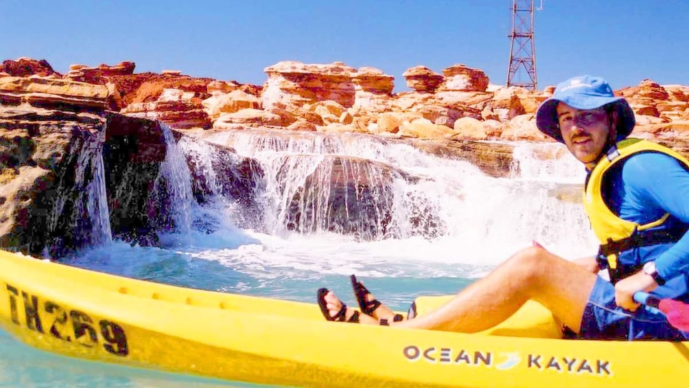 Kayaker on Broome Sea with waterfall in background in Australia.