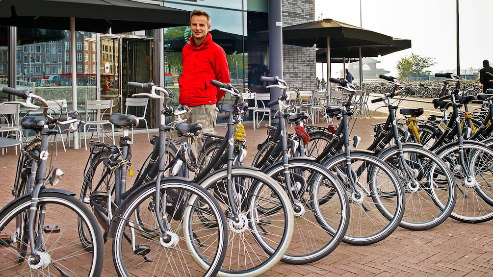 Foto 5 von 9 laden Man with row of bicycles in Amsterdam