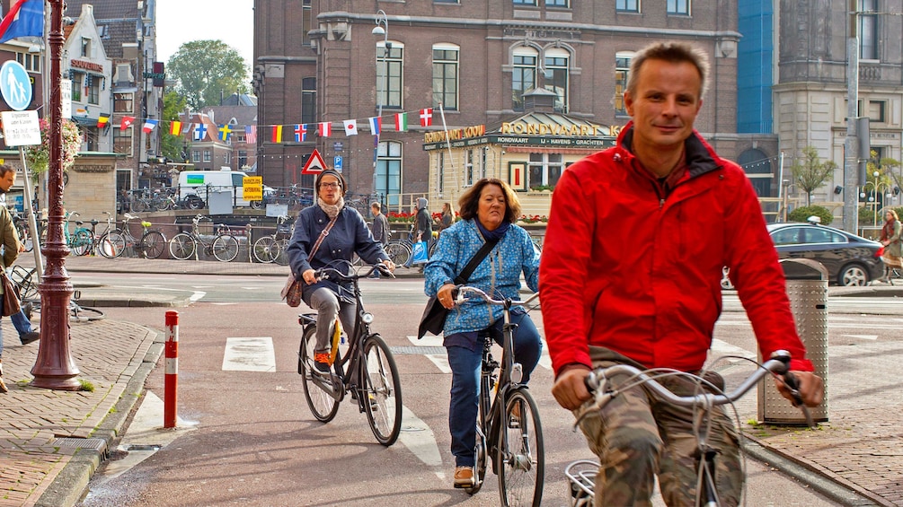 Foto 1 von 9 laden 3 People riding bicycles on brick road in Amsterdam