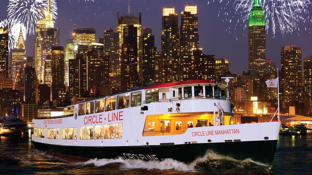 Cruise boat with fireworks and the city at night in New York