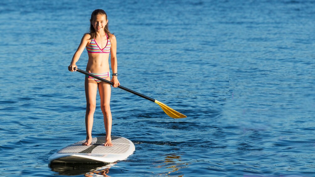 Young girl on standup paddle board in Brisbane Australia. 