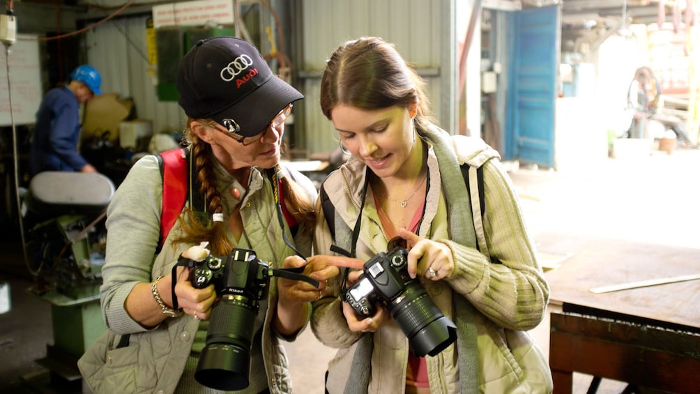 Two photographers reviewing images on their cameras