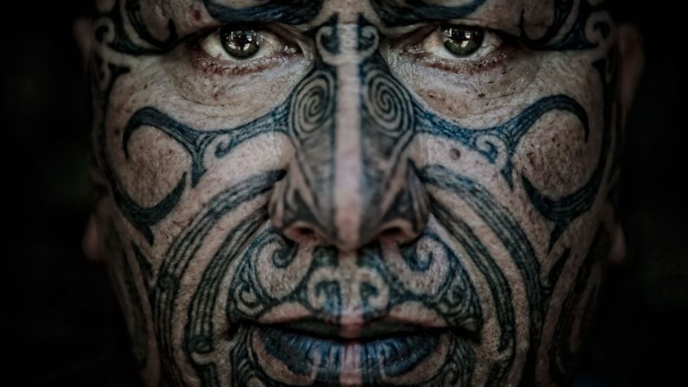 Closeup of a Maori man's face with tattoos