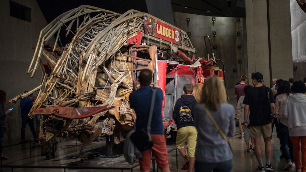 People looking at the remains of fire engine at the National September 11 Memorial Museum in New York