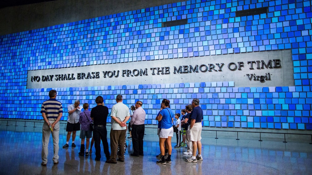 People standing near quote mural on wall at  the National September 11 Memorial Museum in New York