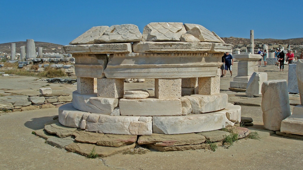 People walking between the ruins on Delos