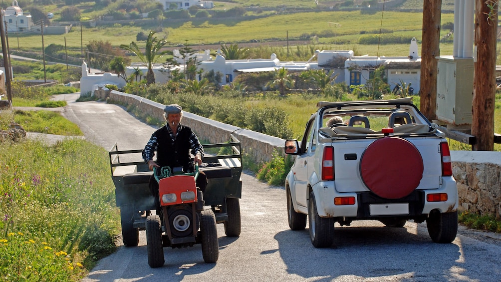 Jeep on a narrow road through fields and farmland on Mykonos